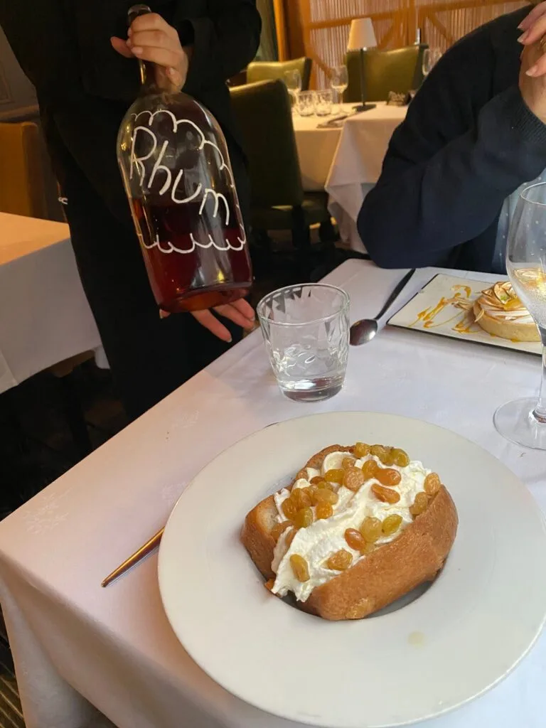 Rum baba with whipped cream and raisins at a restaurant