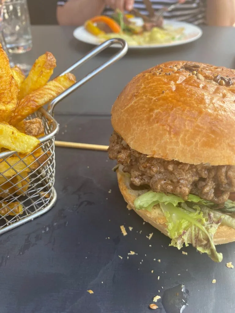 A generous burger with a salad and a basket of homemade chips