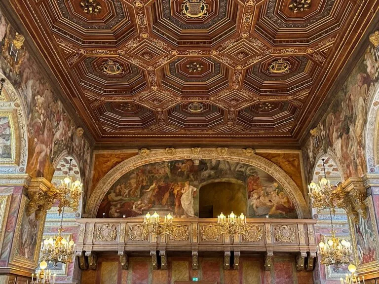 The Golden Renaissance Room with a coffered ceiling and wall frescoes