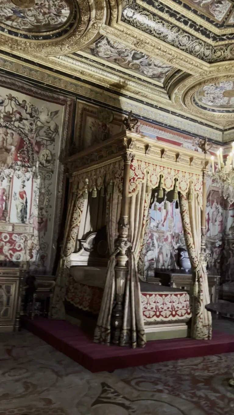 Royal bedroom with a gilded four-poster bed and a Baroque ceiling