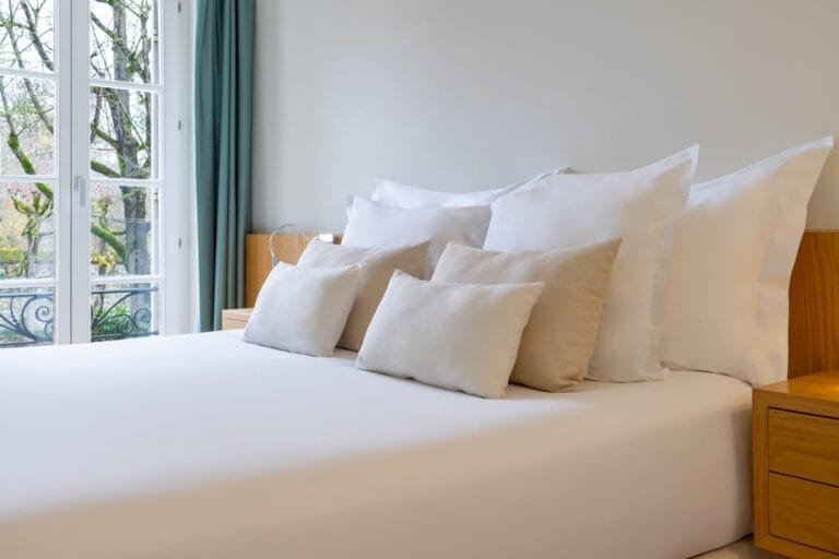 Chambre bleue avec lit douillet et rideaux à l'Hôtel de Cavoye Fontainebleau