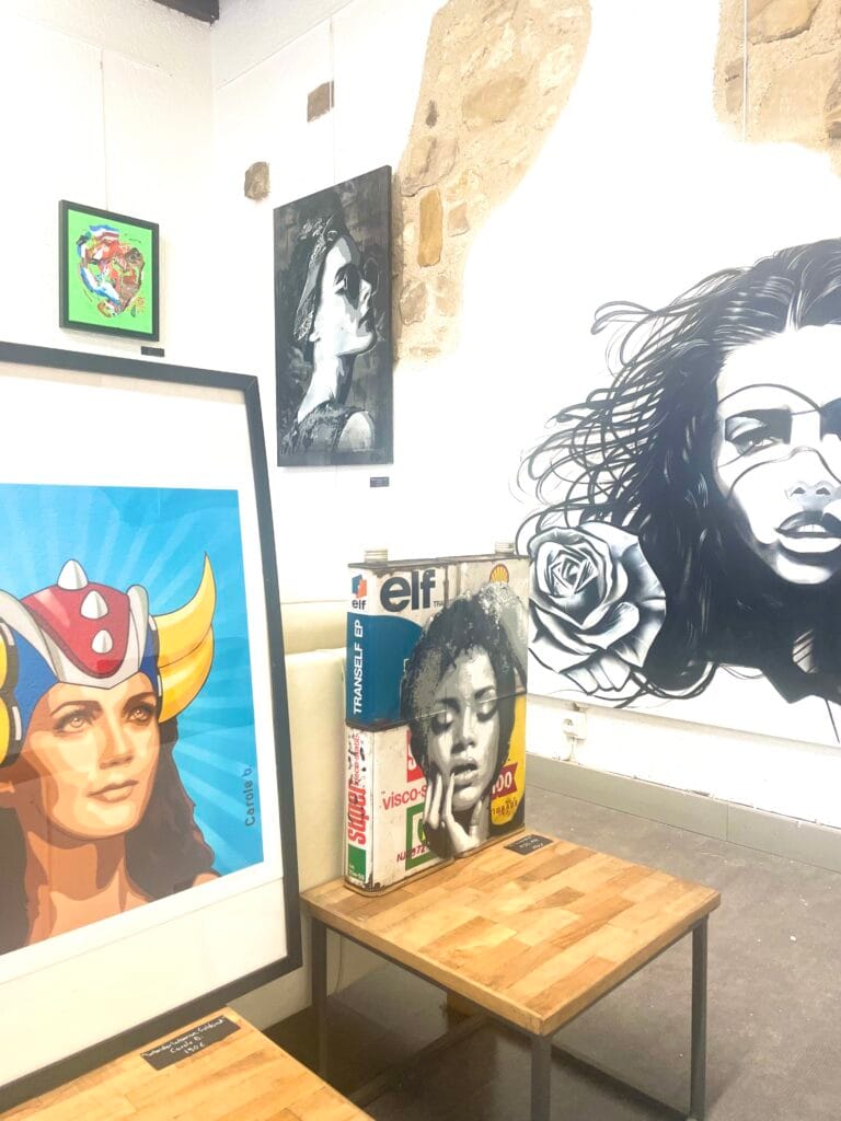 Exposition d'art avec portraits colorés et noir et blanc.