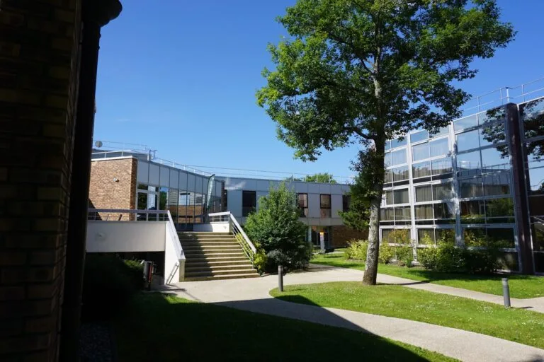 Modern campus buildings with a staircase and lush gardens