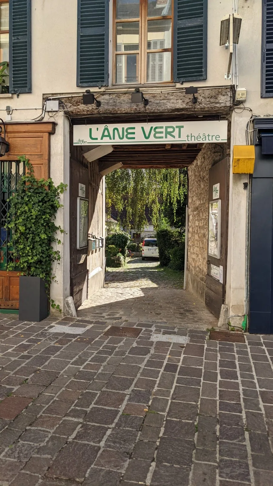 Entrance to the L'Âne Vert theatre with a paved vaulted passageway