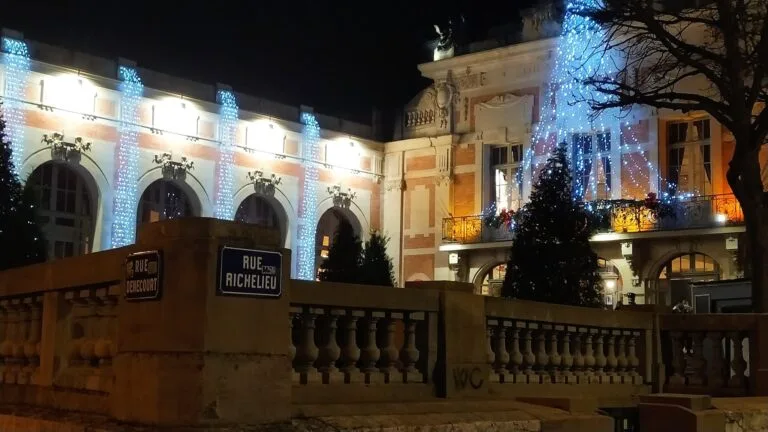 A historic building lit up with blue fairy lights at night