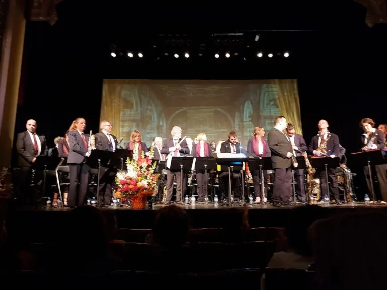 An orchestra performing on a floodlit stage