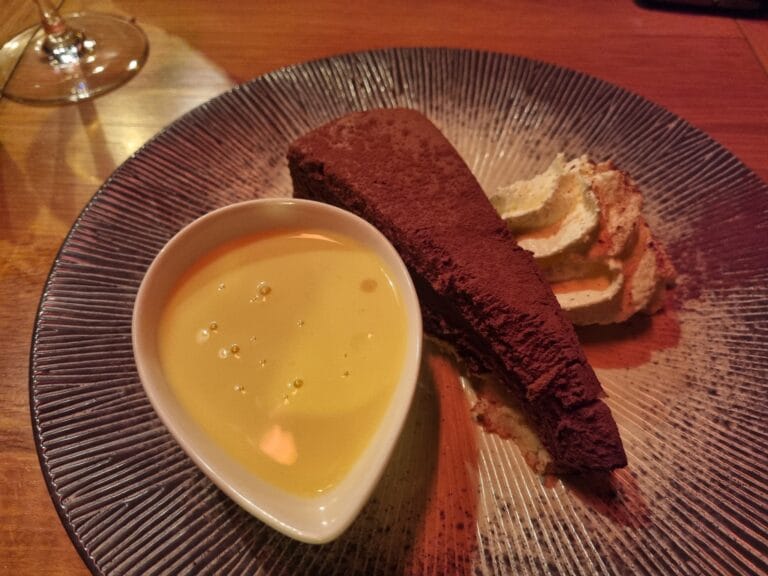 Dessert au chocolat saupoudré de cacao avec crème anglaise et biscuit roulé – Le Mécano Fontainebleau