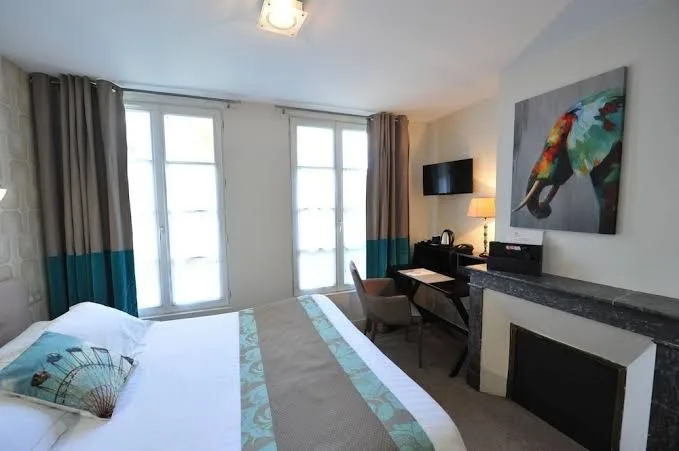 Zimmer im Hotel The Originals Boutique Victoria Fontainebleau mit Doppelbett, Kamin und buntem Elefantenbild