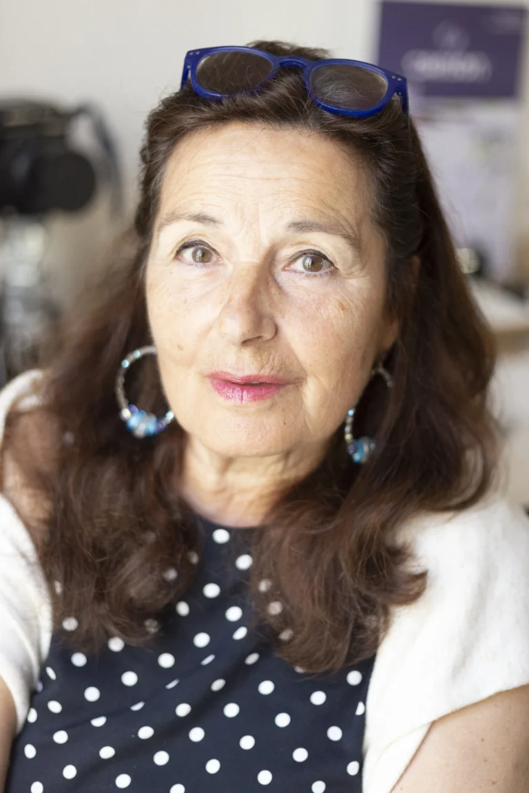 Portrait of Albertine Gentou, a dark-haired woman with blue glasses on her head