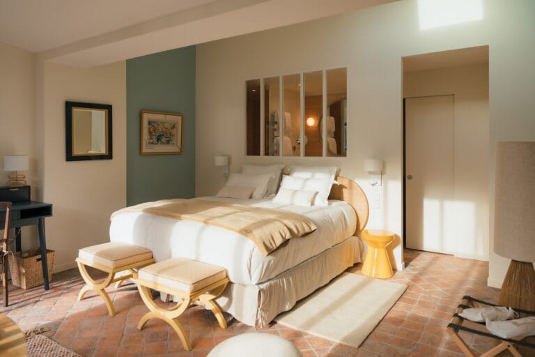 Room at the Esquisse Hôtel Culturel in Fontainebleau, double bed with yellow benches and view of glass-roofed bathroom