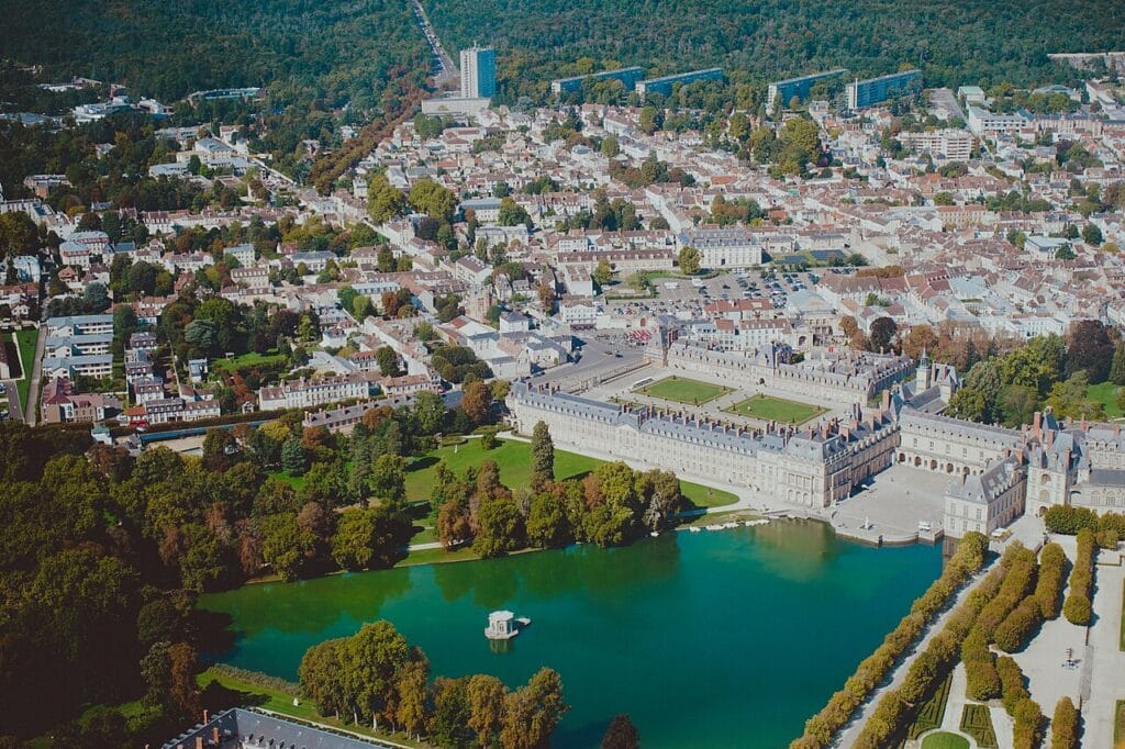 Vue aérienne du Château de Fontainebleau et de l'étang aux carpes entouré de jardins verdoyants