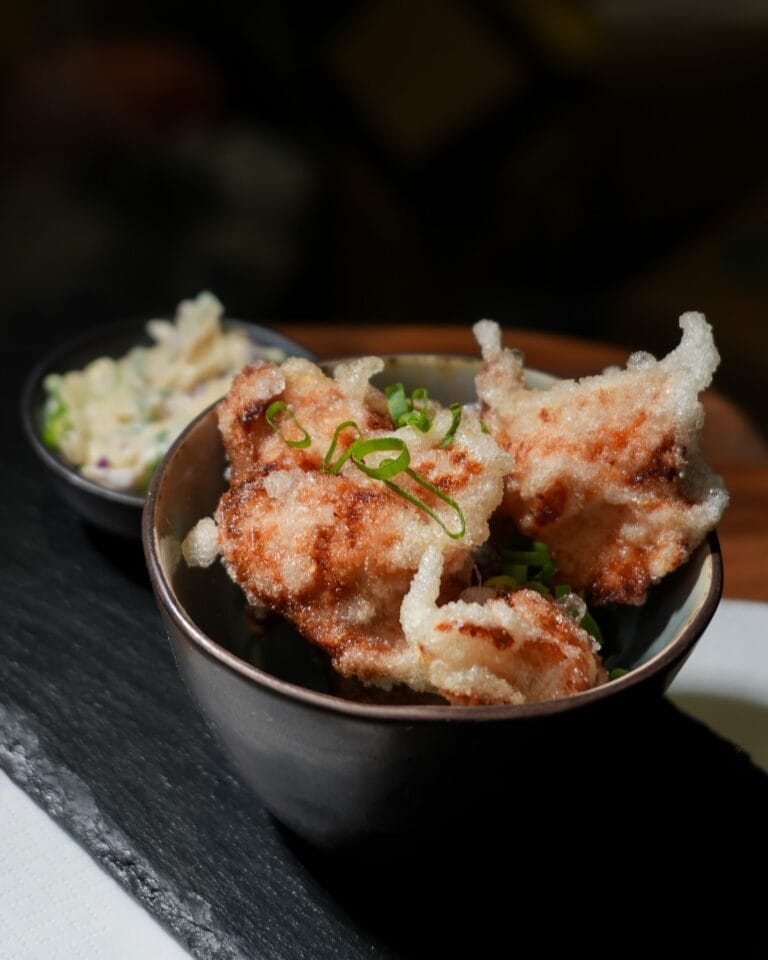 Assiette de fritures croustillantes avec coleslaw dans un bol sombre – L'Office bar à jeux de Fontainebleau