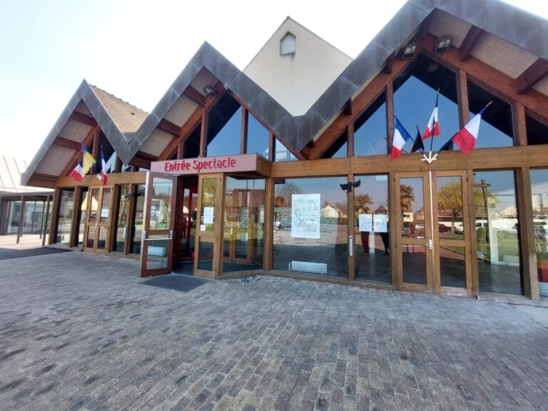 Spectacle entrance to the Sources Vives multimedia library in Avon, a modern building with flags and V-shaped roofs