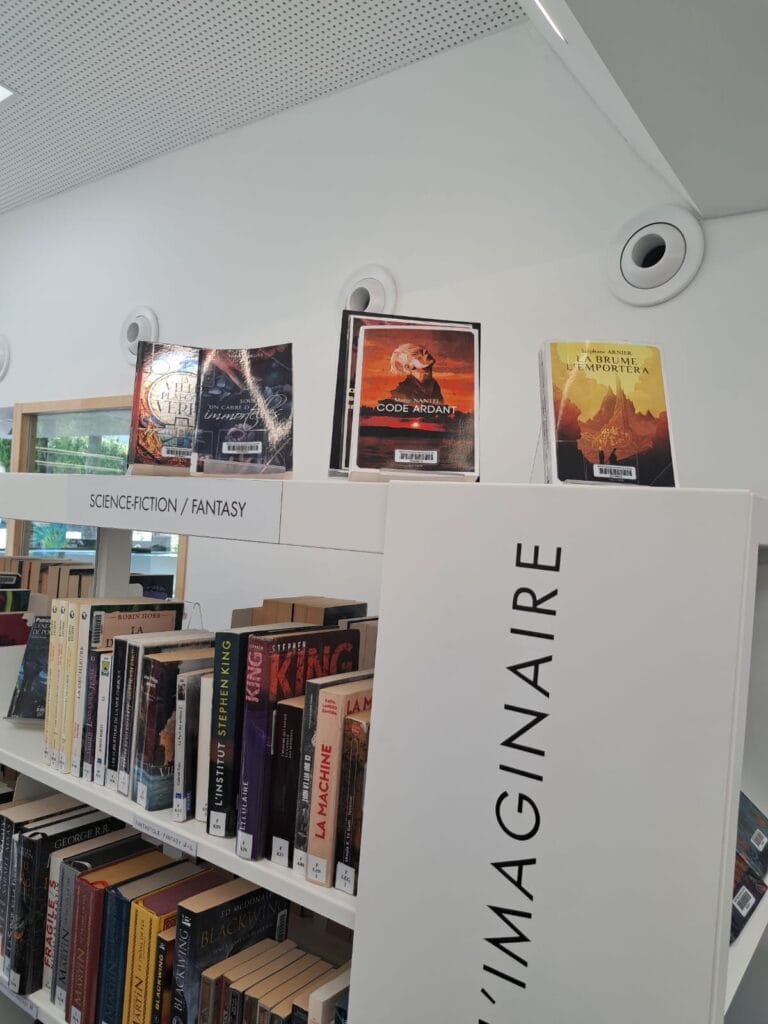 Science Fiction and Fantasy section at Les Sources Vives multimedia library in Avon, books highlighted on white shelves