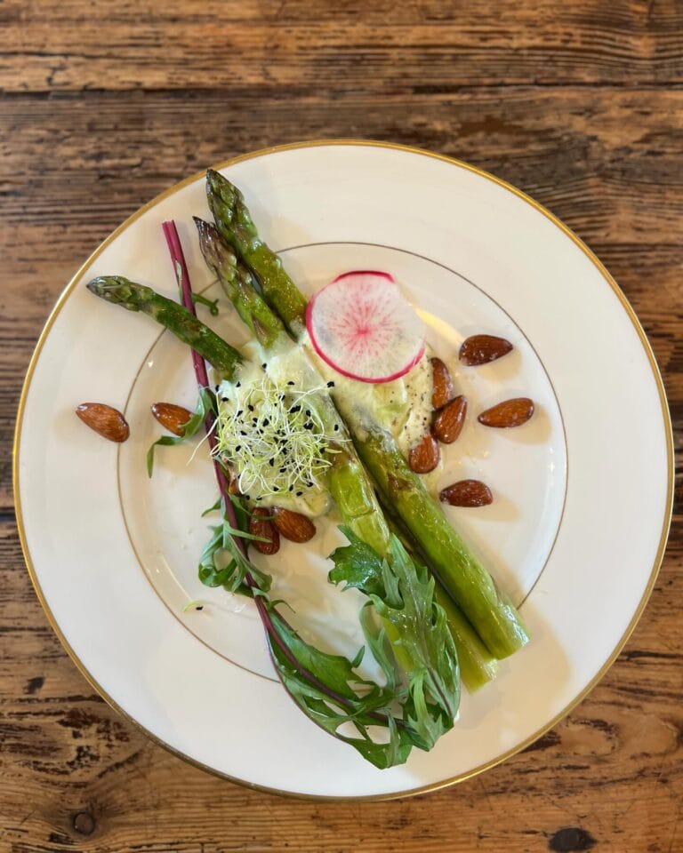 Plate of green asparagus, roasted almonds, radishes and sprouts, seasonal cuisine Maison Sumac