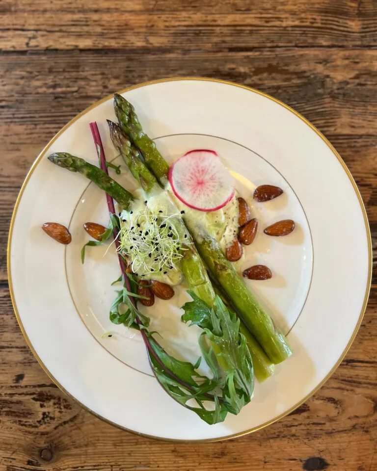 Plate of green asparagus, roasted almonds, radishes and sprouts, seasonal cuisine Maison Sumac