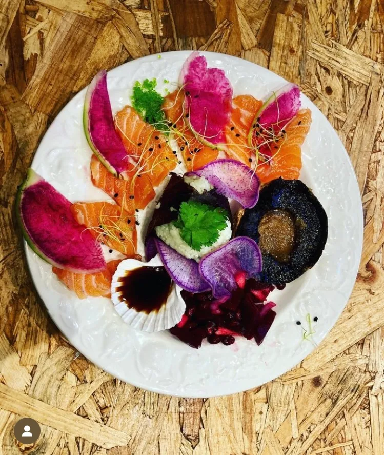 Platter of fresh salmon, watermelon radish, scallops and seaweed, colourful presentation