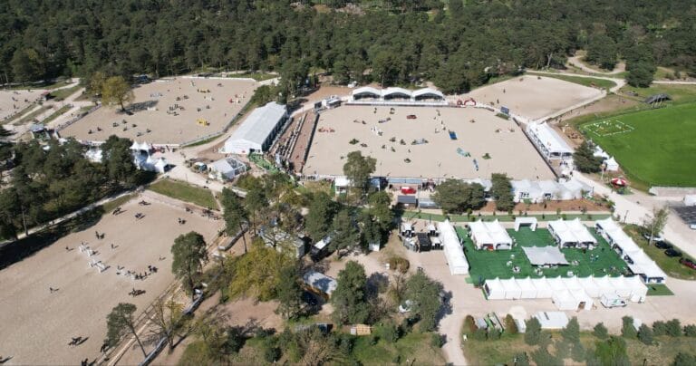 Luftaufnahme eines Reitkomplexes mit Reithallen und Paddocks