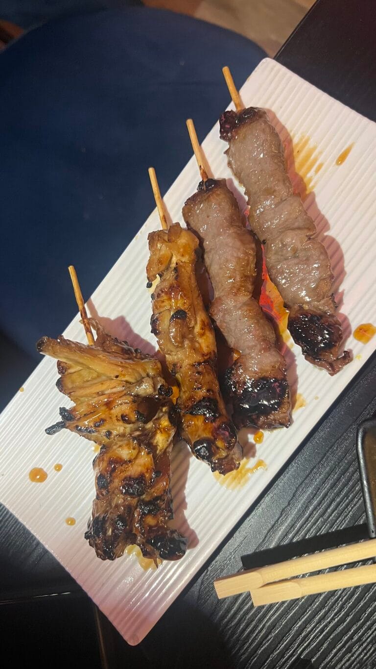 Gegrillte Yakitori-Spieße mit Huhn und Rind, serviert auf einem weißen Teller