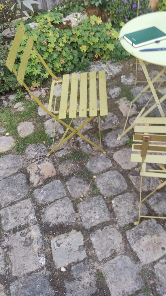 Tables de bistrot jaunes et pavés dans la cour de l'Âne Vert Théâtre à Fontainebleau